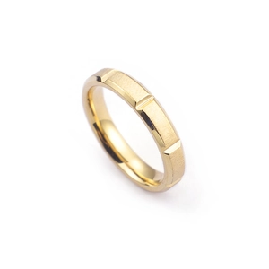 Brushed gold stainless steel ring with geometric engravings on a white background