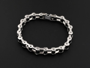 Close-up of silver stainless steel bike chain bracelet with engraved metal clasp detail