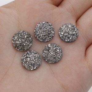 Close-up of 12mm silver resin druzy flatback cabochons with textured glitter finish