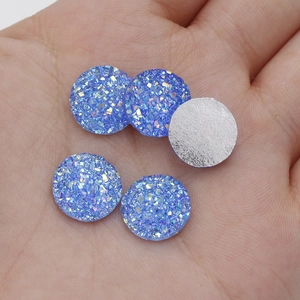 Macro shot of 12mm blue starry resin cabochons with sparkling texture and flat silver back