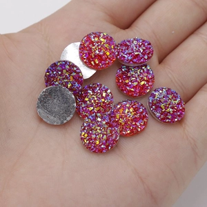 Close-up of 12mm red round resin druzy cabochons with colorful glitter for DIY crafts