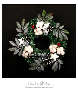 Détail de couronne de Noël avec coton, baies rouges et nœud rayé bleu sur fond noir