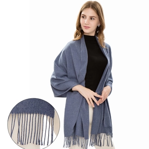 Solid blue scarf with wool texture and tassel detail worn by model on white background