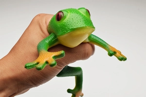 Close-up of flexible green toy frog being squeezed to show elastic rubber material
