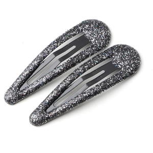 Détail macro de deux barrettes clic-clac noires pailletées en forme de goutte d'eau