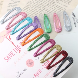 Gros plan de 10 barrettes à cheveux pailletées colorées sur une carte décorative