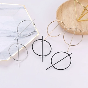 Minimalist geometric hoop earrings shown in gold, silver, and black on a marble tray