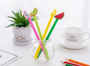Close-up of cute fruit-shaped gel pens featuring watermelon and kiwi slices in a glass jar
