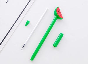 Disassembled green watermelon gel pen showing the refill, cap, and slice topper