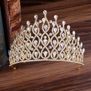 Detailed close-up of a luxury gold bridal crown with crystals on a vintage wood surface