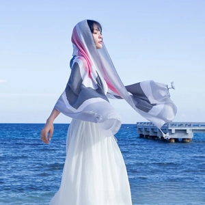 Close-up of color-block striped scarf with tassels fluttering against a blue sea background