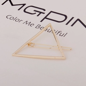 Close-up of a minimalist golden triangle hair clip on a clean white display background