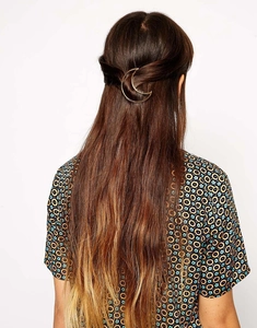 Golden moon-shaped metal hair clip styled on hair for a geometric minimalist look