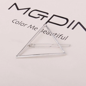Detail view of a metallic silver triangle hair clip with minimalist geometric design