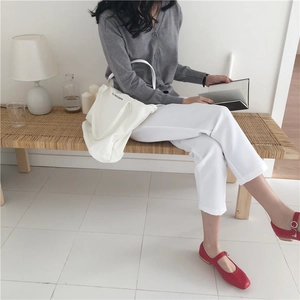 Minimalist white canvas tote bag paired with grey knit cardigan and red Mary Jane flats