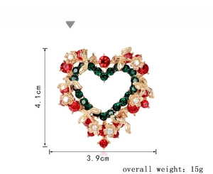 Detail view of heart-shaped Christmas wreath brooch with red and green rhinestones