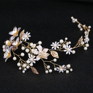 Dettaglio della fascia da sposa con foglie dorate, perle bianche e fiori di strass