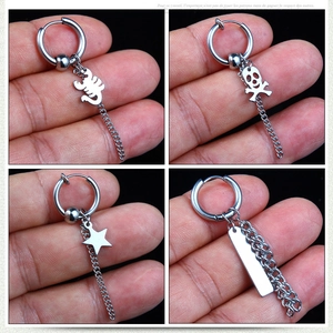 Close-up of titanium steel earrings with skull, scorpion, and tassel chain charms