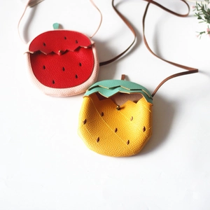 Close-up of litchi texture on pineapple and strawberry shaped mini crossbody bags for kids