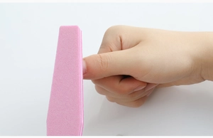 Macro shot of a pink nail sponge buffer being used to shape and smooth nail edges