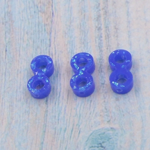 Blue infinite opal beads with sparkling particles on a light blue wooden texture surface