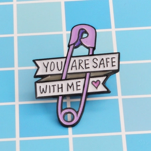 Detailansicht einer lila Emaille-Brosche mit dem englischen Zitat YOU ARE SAFE WITH ME