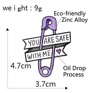 Purple safety pin enamel brooch featuring You Are Safe With Me banner and heart