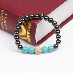 Close-up of magnetic hematite beads and turquoise stone on a red book backdrop