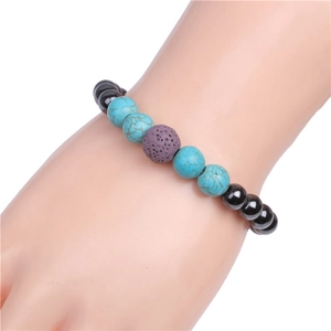 Detailed view of turquoise and purple lava beads on a magnetic elastic bracelet