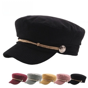 Detailed texture of thick corduroy flat cap with rope trim and gold decorative button