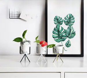 Three gray marble ceramic pots with black, white, and gold iron tripod stands