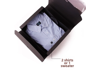 Macro view of blue gingham shirt folded in premium matte black magnetic gift box