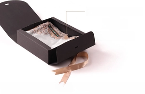 Detail view of black matte flip-top gift box with silk scarf and champagne ribbon inside