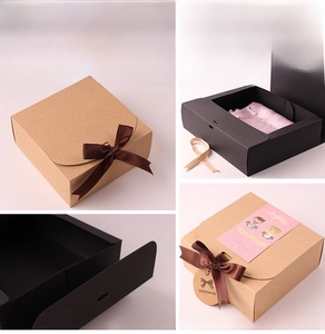 Detail of matte black and kraft gift boxes with satin ribbons and handmade tags