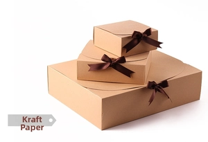Three-tier stack of kraft paper gift boxes with dark brown ribbon bows on white background