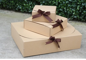 Three-piece kraft paper gift box set with dark brown ribbon bows in multiple sizes