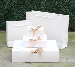 White gift box set with champagne gold ribbon bows and matching paper gift bags
