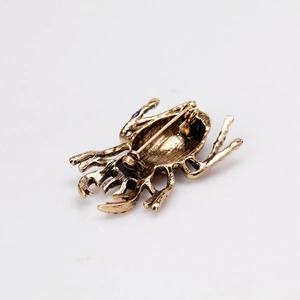Vintage beetle brooch in antique gold finish showing the back safety pin closure details