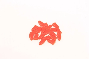 Macro view of bright orange silicone pet nail covers for cats and dogs on white background