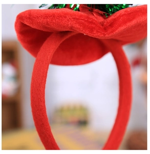 Détail d'un serre-tête festif en velours rouge avec garniture en guirlande verte