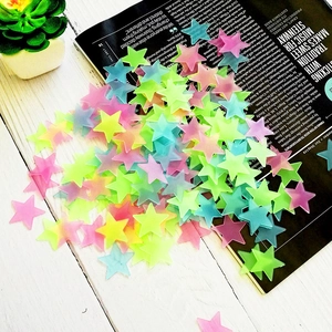 Close-up of 3D fluorescent glow stars in pink, yellow, and green on an aesthetic desk setup
