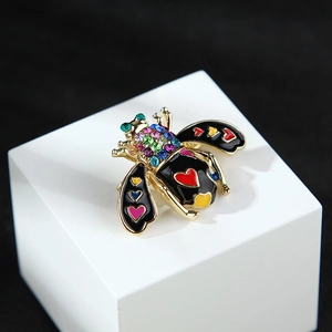 Detailed macro view of bee brooch with colorful rhinestones and enamel heart patterns