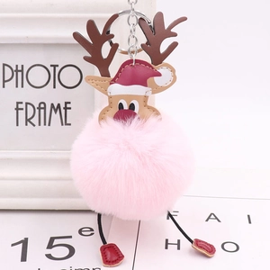 Detail of Christmas reindeer plush keychain featuring a pink faux fur pompom and festive hat