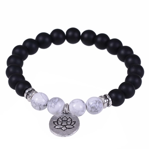 Lava stone and white turquoise beaded bracelet with lotus pendant on white background