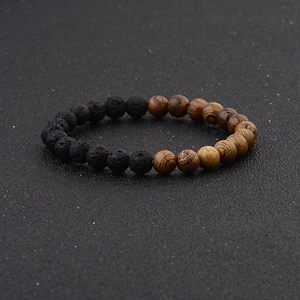 Detail of natural wood beads and black porous lava stones on a beaded elastic bracelet
