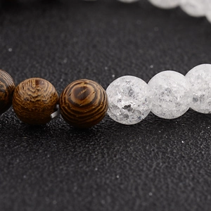 Macro detail of wood grain beads and cracked crystal beads on a beaded bracelet