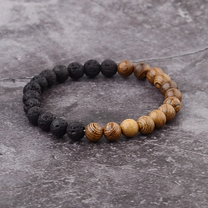 Detail of natural wood and black lava stone beads on an elastic unisex bracelet