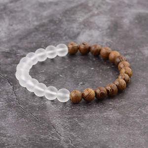Detailed view of matte white beads and brown wood grain beads on a stone surface