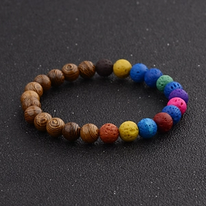 Close-up of beaded bracelet with brown wood grain and colorful volcanic lava stones