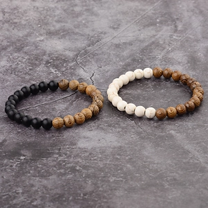 Detail of wooden grain beads and matte black stones on a beaded bracelet pair